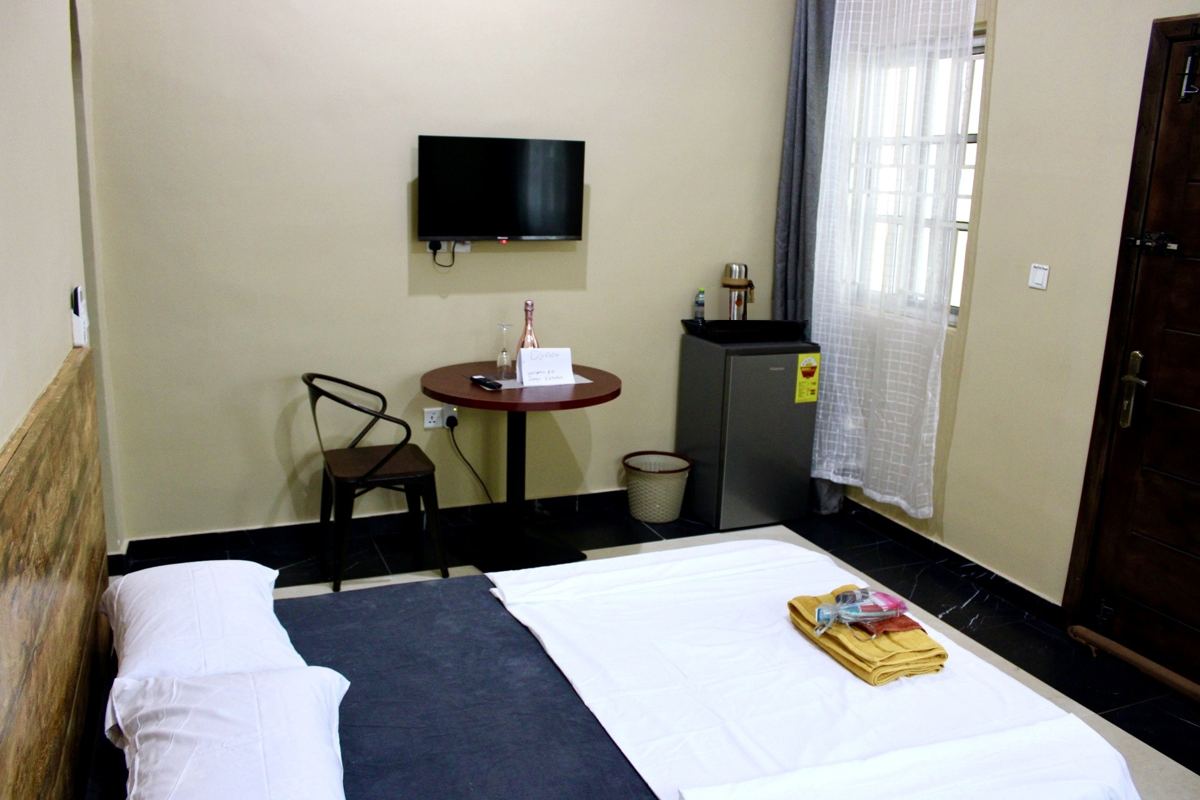Economy studio suite with full size bed, AC, smart TV, sofa, dining table, mini fridge and ensuite bathroom