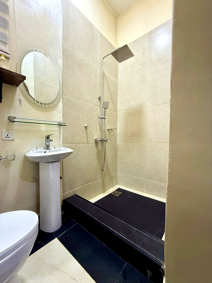 Economy studio suite, Studio suite bathroom with rainfall shower and pedestal sink