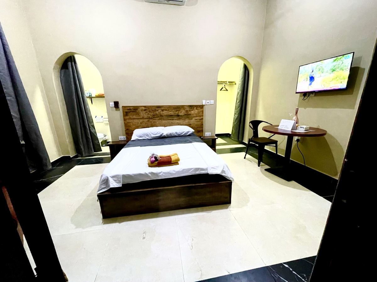 Studio suite with full size bed, AC, arched alcoves, wall-mounted TV and table