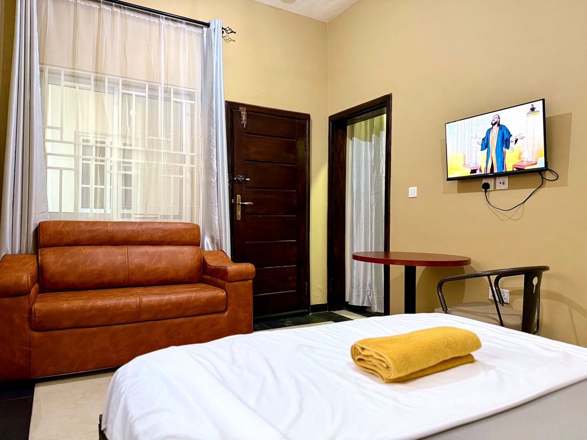 Queen studio suite with queen size bed, AC, smart TV, sofa, dining table, mini fridge and ensuite bathroom