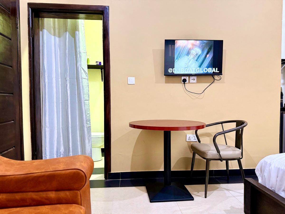Queen studio suite with queen size bed, AC, smart TV, sofa, dining table, mini fridge and ensuite bathroom