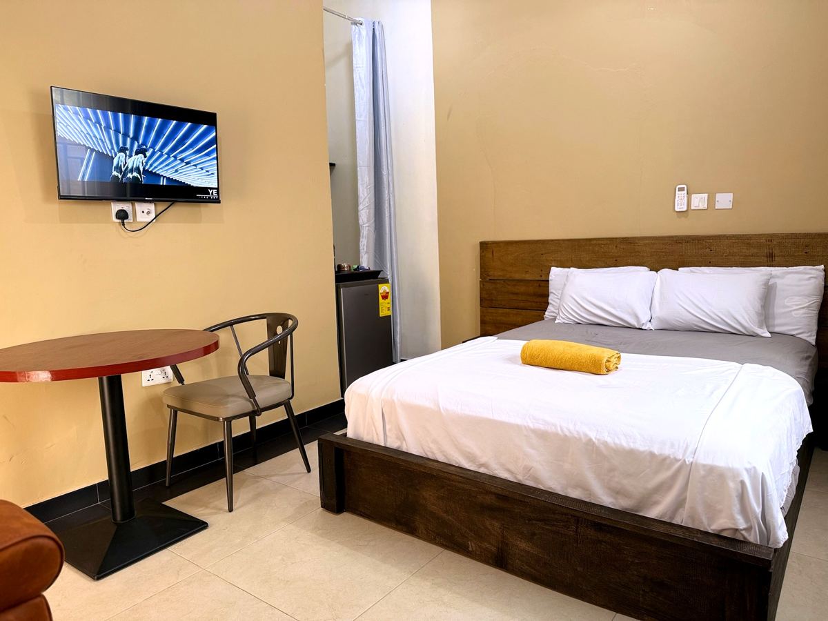 Queen studio suite with queen size bed, AC, smart TV, sofa, dining table, mini fridge and ensuite bathroom