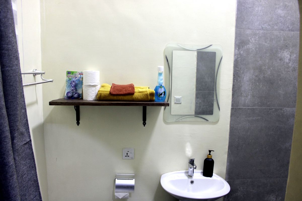 Queen studio suite bathroom shelf with towels, mirror and sink